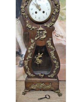 Le village de 58 brocanteurs - Horloge de maitrise en bois teinté, ornée d’une iconographie d’amours en bronze doré